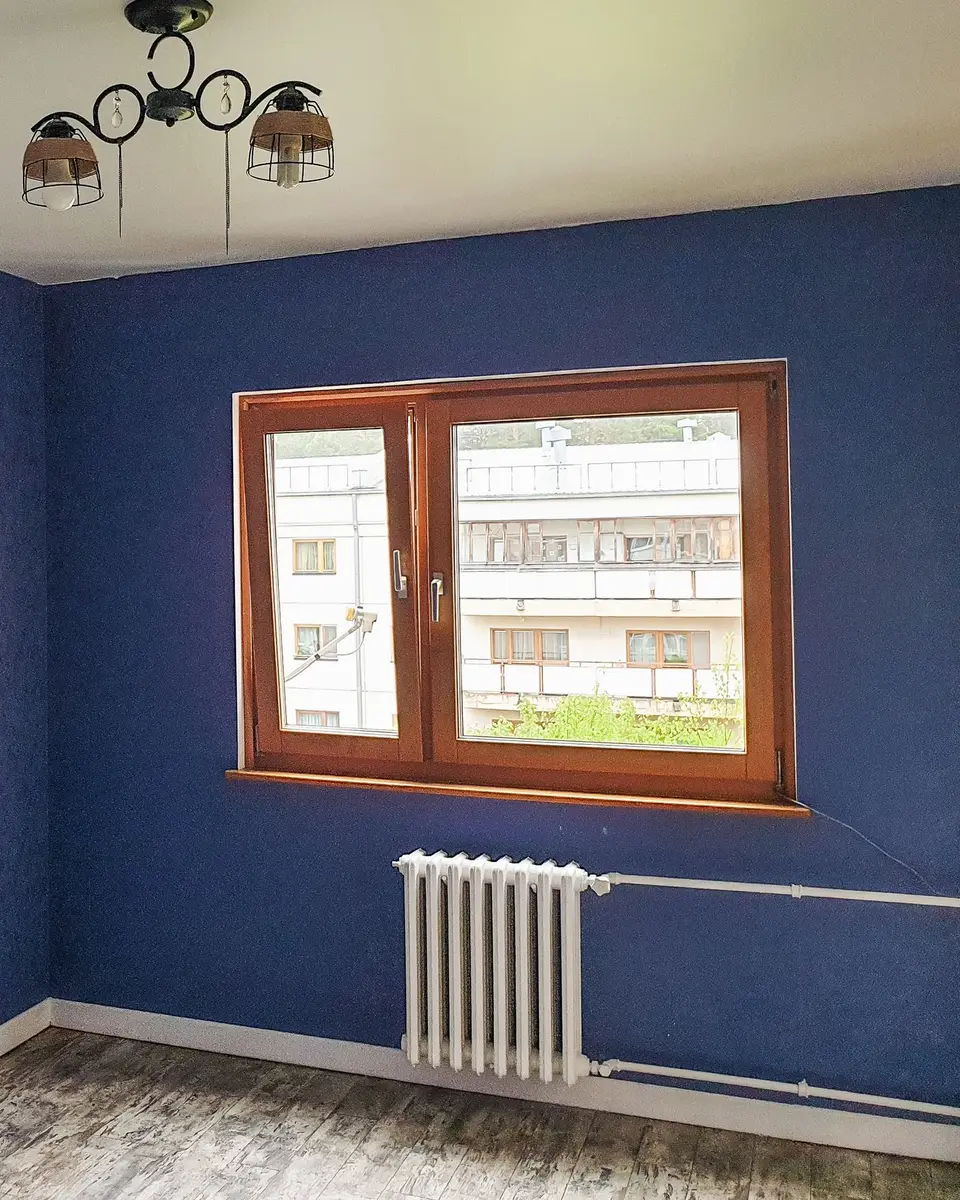 Empty room with blue walls and a wooden window