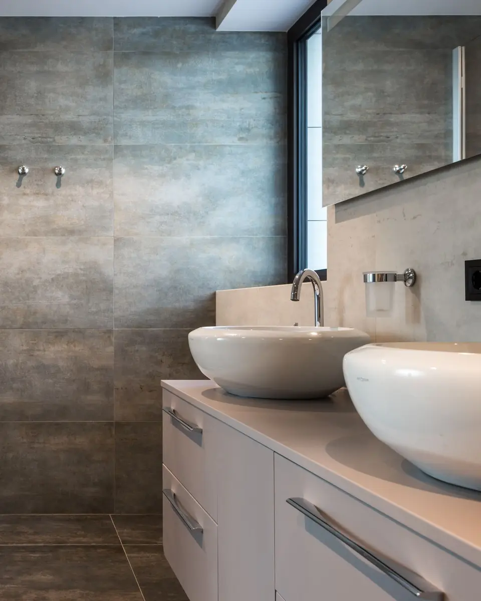 Concrete-effect bathroom wall above two round basins