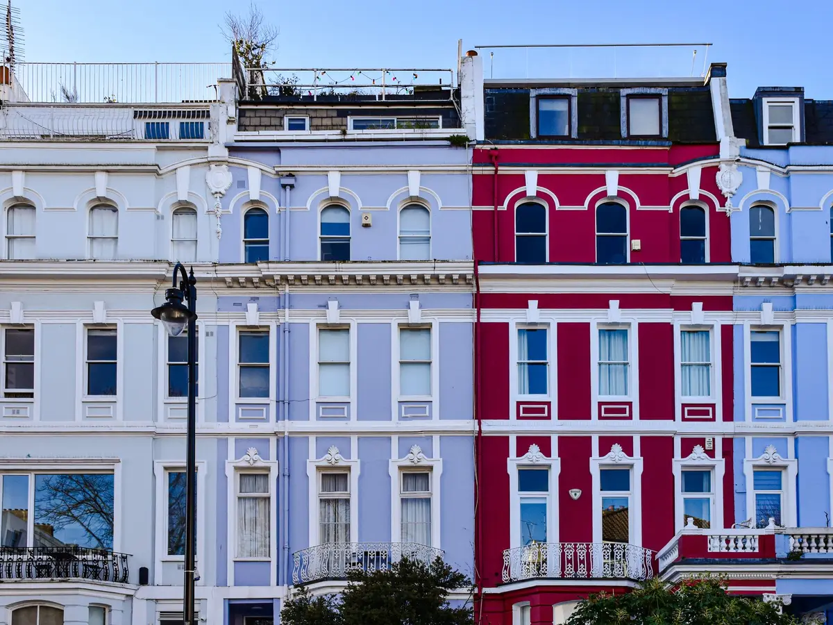 White and crimson rendered townhouses with moulded window surrounds